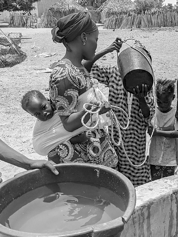Des femmes et des enfants boivent l'eau de leur puits au Sénégal